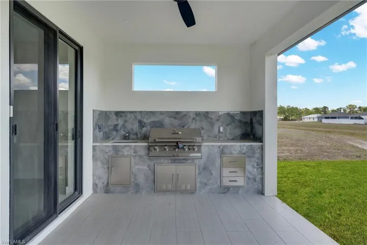 View of patio featuring exterior kitchen and a ceiling fan