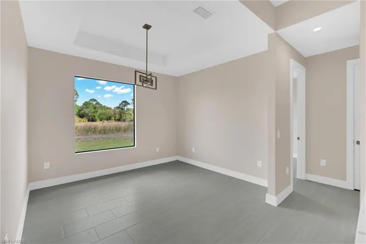 Spare room featuring baseboards and a raised ceiling