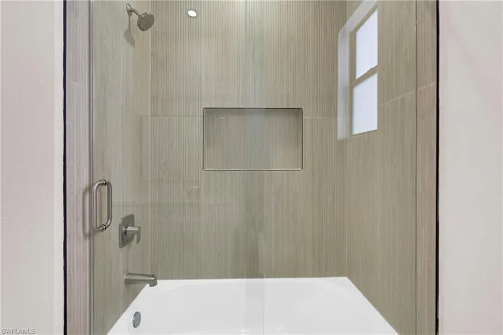 Bathroom featuring shower / bath combination with glass door