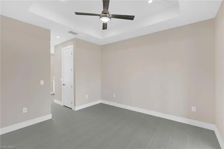 Spare room featuring ceiling fan, a raised ceiling, and recessed lighting