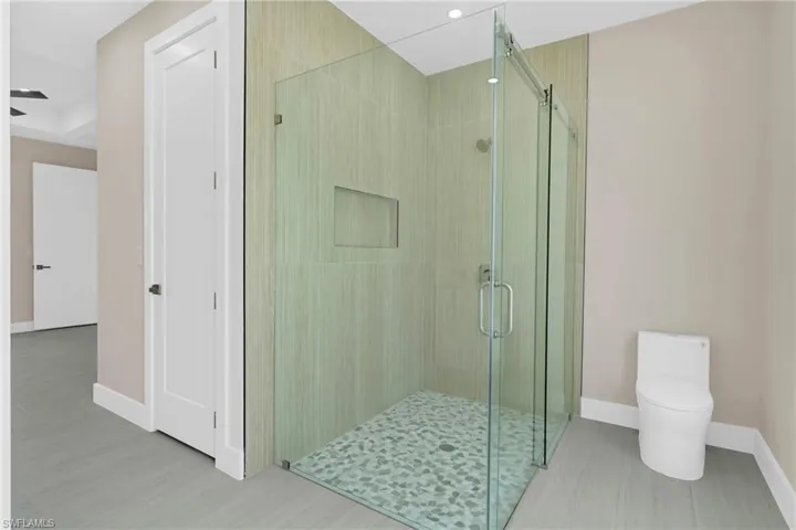 Bathroom featuring baseboards and a stall shower
