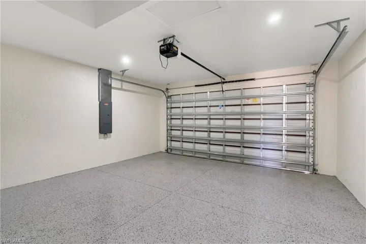 Garage with electric panel and a garage door opener
