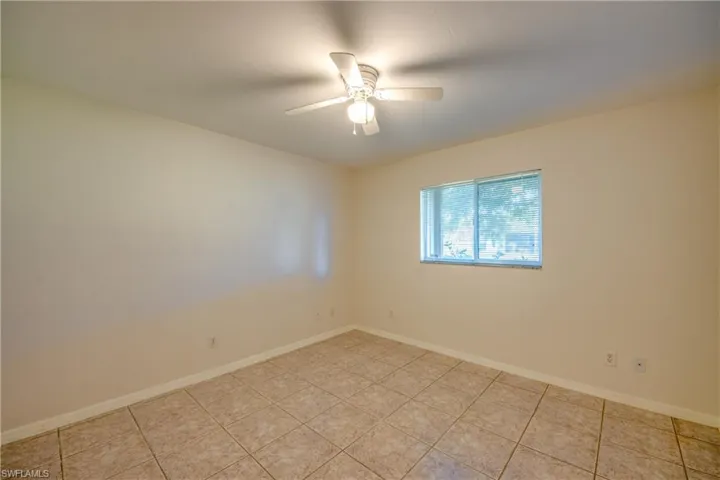 Tiled empty room with ceiling fan