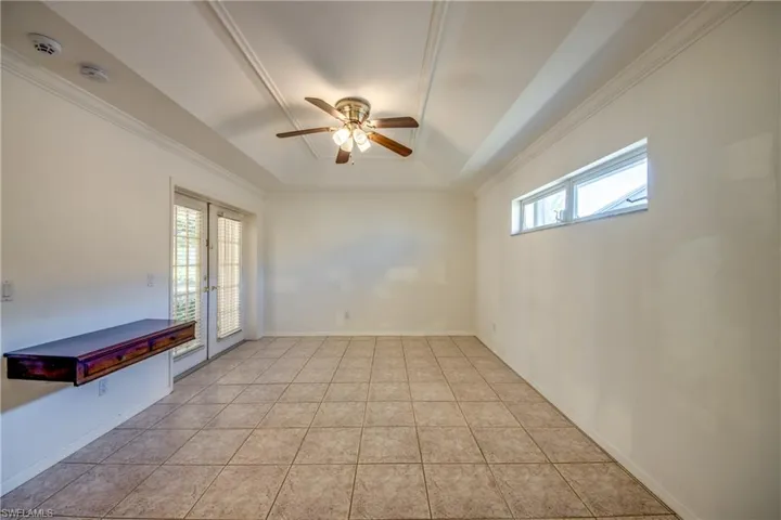 Spare room with a wealth of natural light, a raised ceiling, and light tile patterned flooring
