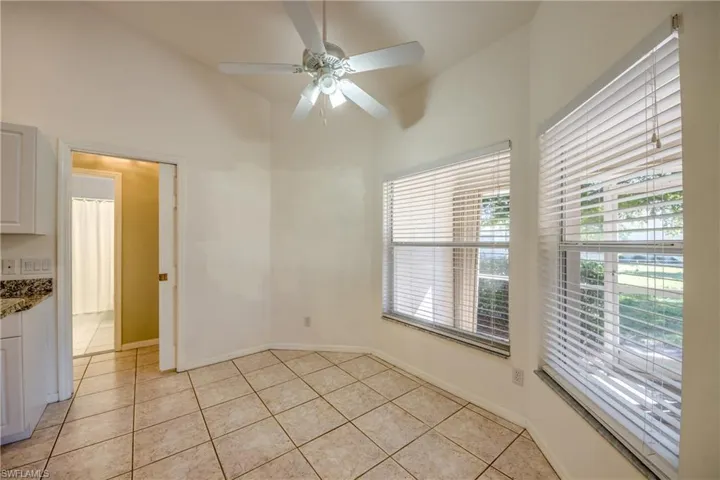 Tiled empty room featuring high vaulted ceiling and ceiling fan