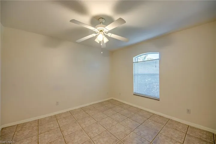 Tiled empty room with ceiling fan