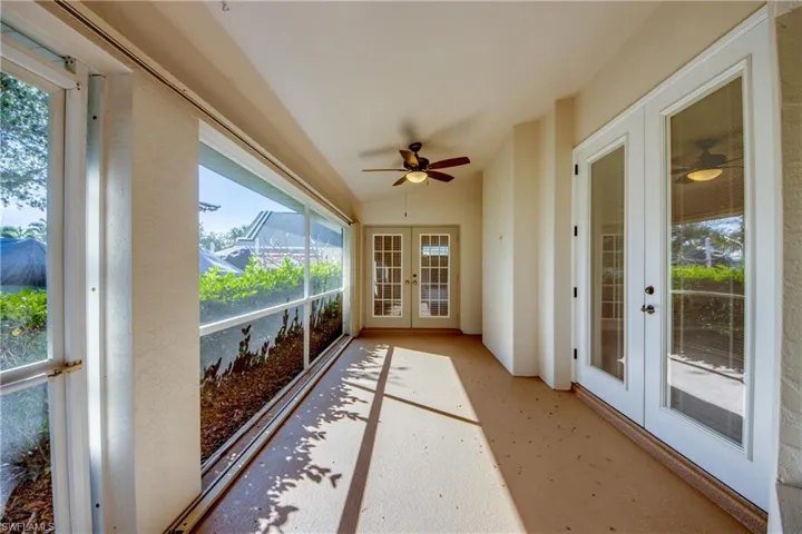 Sunroom / solarium featuring vaulted ceiling, ceiling fan, and french doors