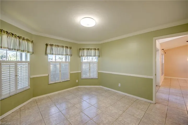 Tiled empty room featuring ornamental molding