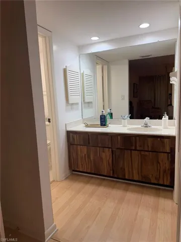 Double vanity with undermount sinks, light countertop, and rich wood-finish cabinetry