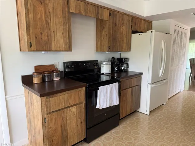 Kitchen space featuring wood-finish cabinetry and dark countertops
