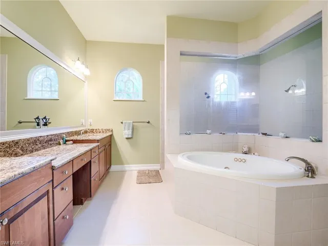 Bathroom with shower with separate bathtub, vanity, tile patterned floors, and plenty of natural light