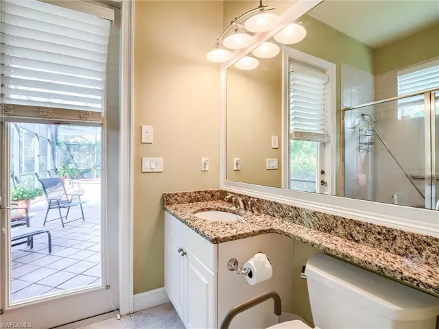 Bathroom with walk in shower, toilet, and plenty of natural light