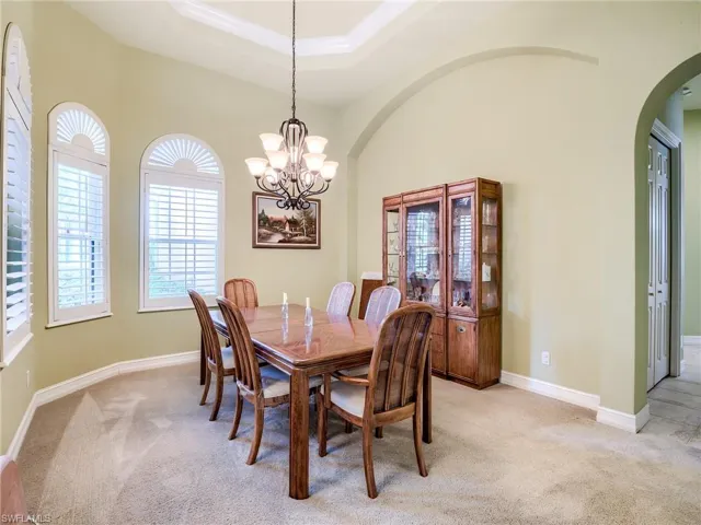 Carpeted dining area with a notable chandelier