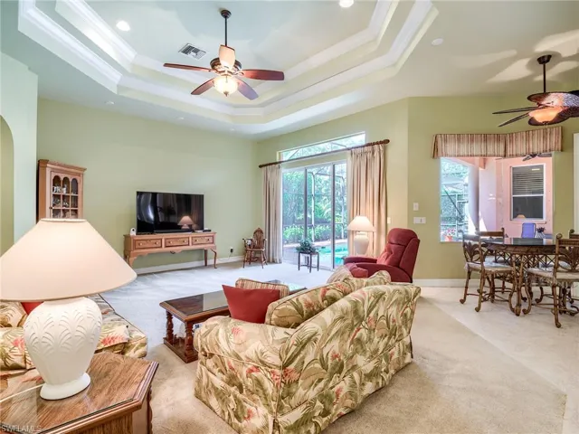 Living room featuring light carpet and ceiling fan