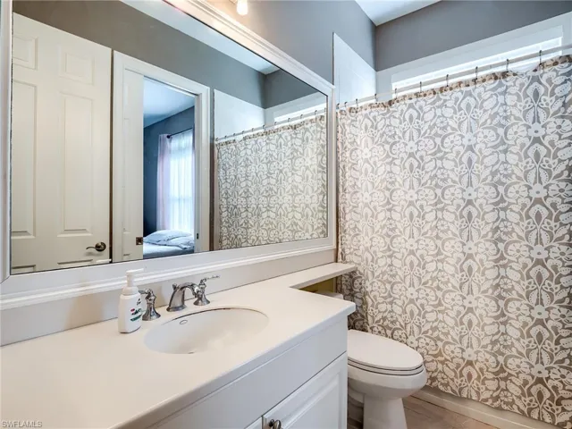 Bathroom with walk in shower, vanity, and toilet