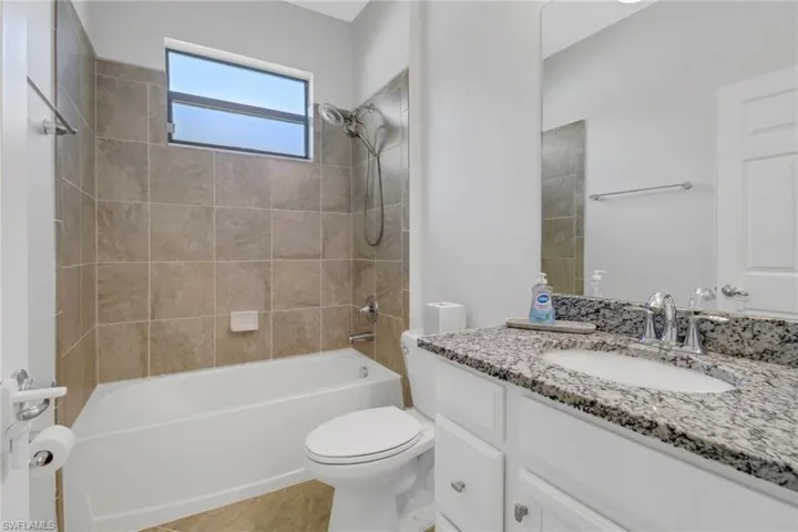 Bathroom featuring toilet, shower / tub combination, and vanity