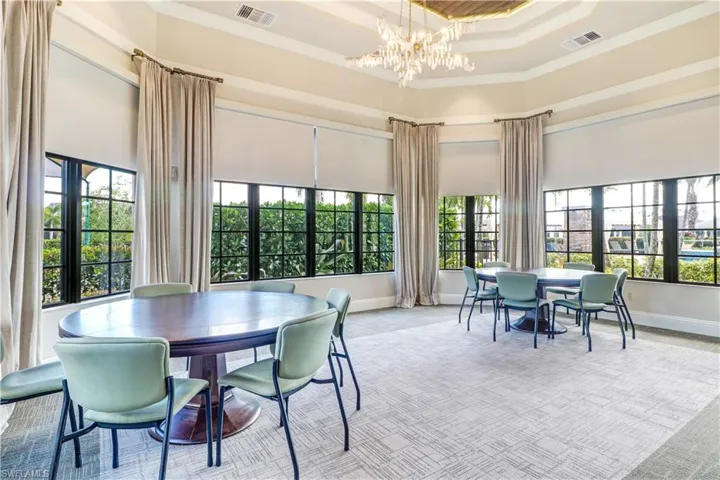Dining space with visible vents, a high ceiling, and a notable chandelier
