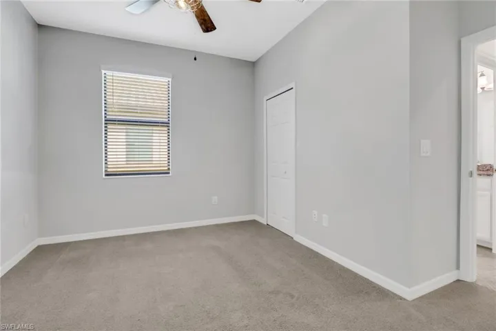 Spare room with baseboards, ceiling fan, and light colored carpet