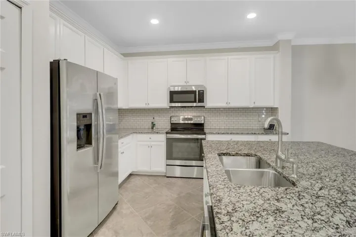 Kitchen with ornamental molding, a sink, stainless steel appliances, and backsplash