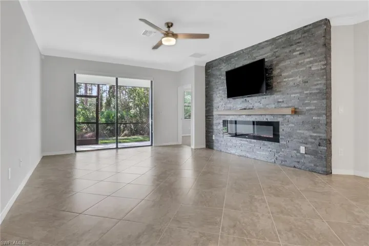Unfurnished living room featuring baseboards, tile patterned floors, ceiling fan, visible vents, and a fireplace