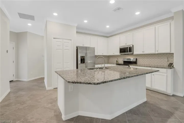 Kitchen with white cabinets, a sink, and stainless steel appliances