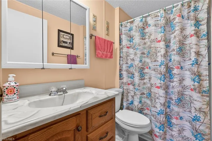 Bathroom featuring a vanity with a white marble-effect countertop, a white sink, and a mirrored medicine cabinet