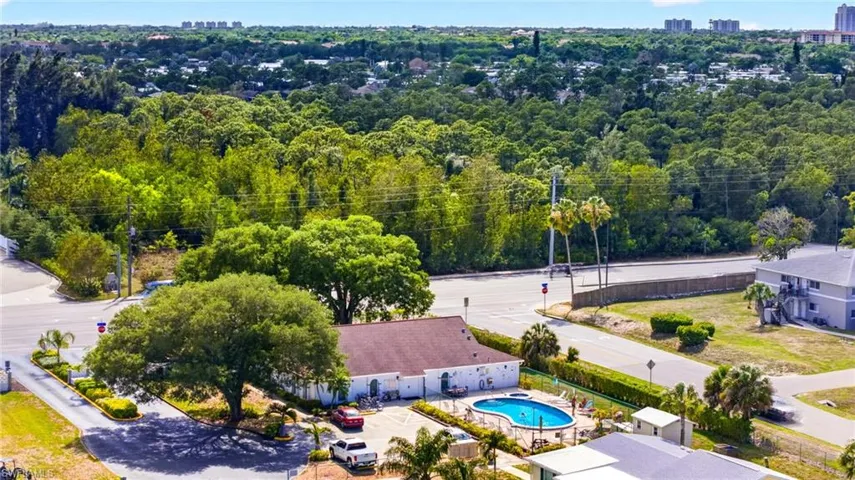 This property features an inviting outdoor swimming pool, surrounded by a paved deck and green fencing