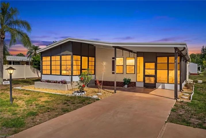 The property features a concrete driveway and a covered entrance