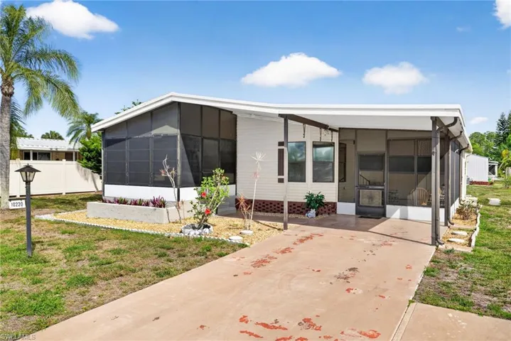 The property features a screened-in porch and a covered carport, offering outdoor living and parking