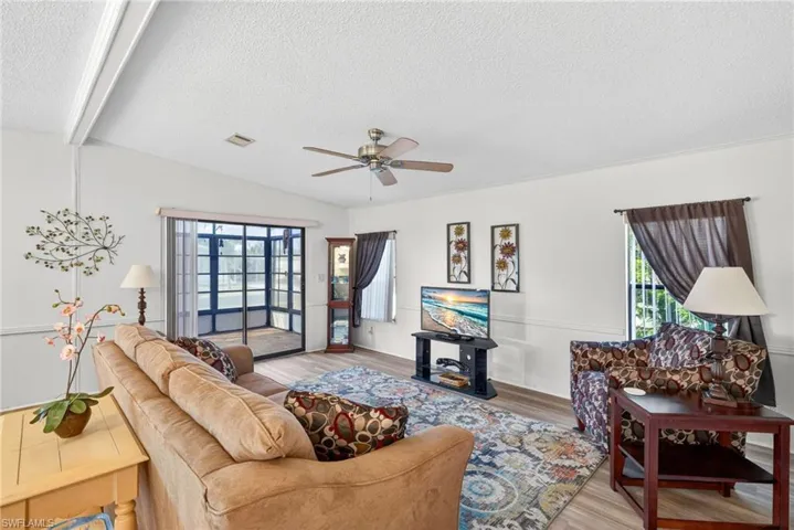 The living area features a ceiling fan, light-colored walls, and flooring