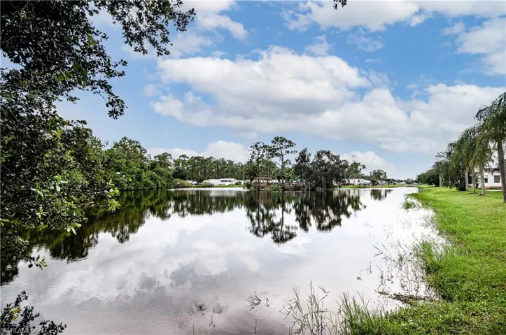 Expansive waterway frontage with reflections of the sky and trees