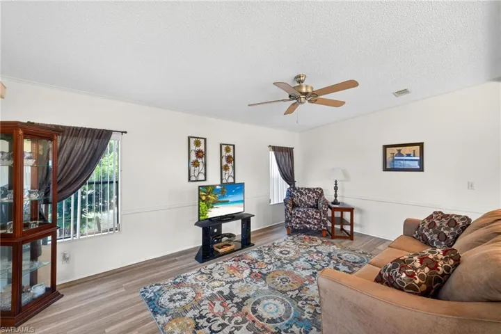 The living area features durable flooring, a ceiling fan, and ample natural light from the window