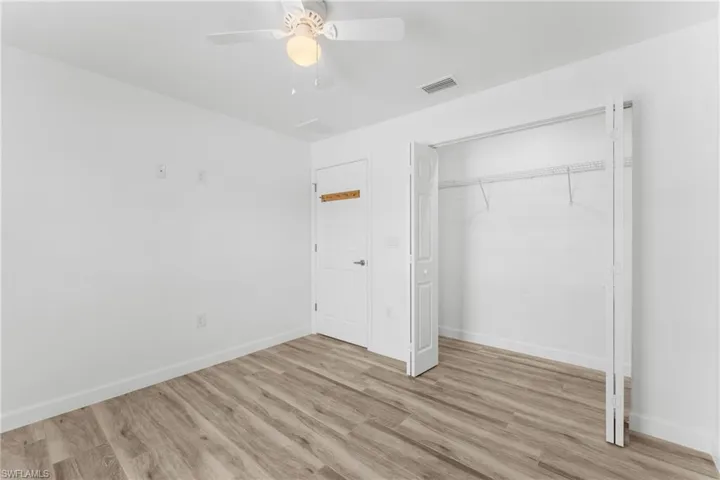 Unfurnished bedroom with light wood-style floors, a ceiling fan, and a closet