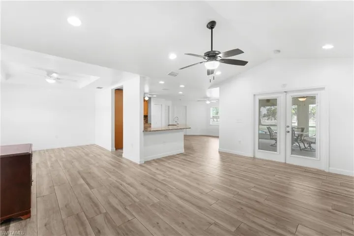 Unfurnished living room featuring light wood-type flooring, ceiling fan, and recessed lighting