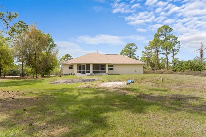 Back of house featuring a sunroom and a lawn