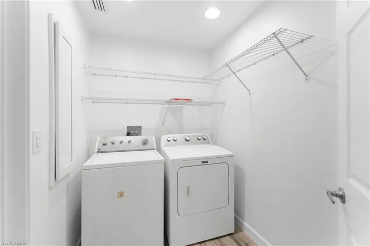 Laundry room with washer and dryer and light wood-type flooring
