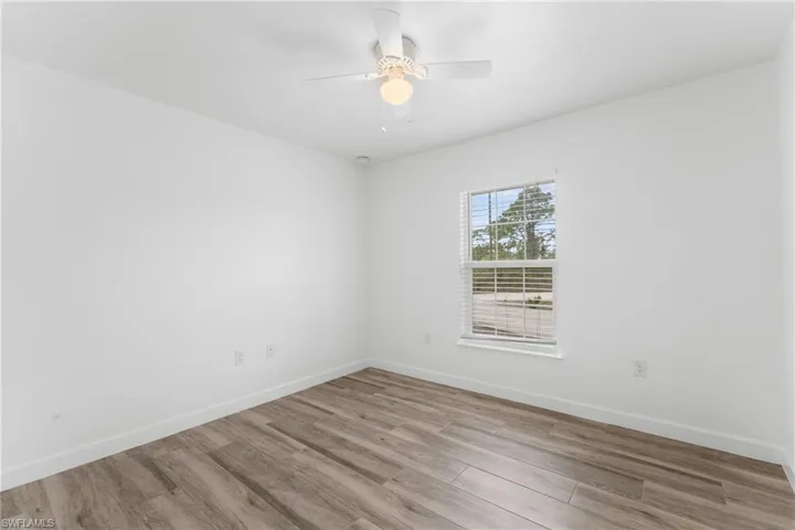 Empty room with light wood-style flooring and ceiling fan