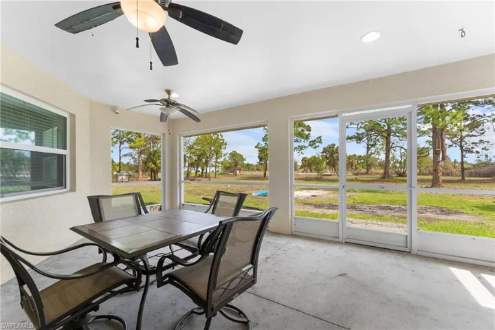 Sunroom / solarium with outdoor dining space and ceiling fan