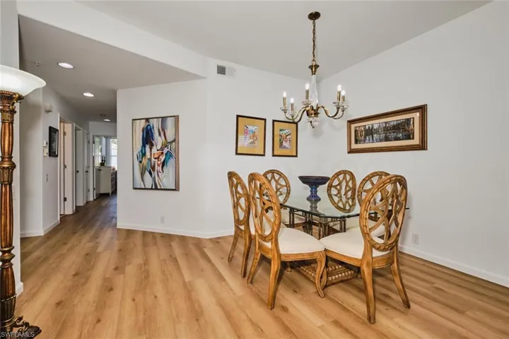 Dining area with light wood finished floors, a chandelier, baseboards, and recessed lighting