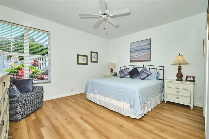Bedroom featuring light wood-type flooring, baseboards, and ceiling fan