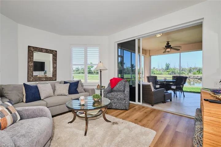 Living area featuring healthy amount of natural light, ceiling fan, wood finished floors, and a water view