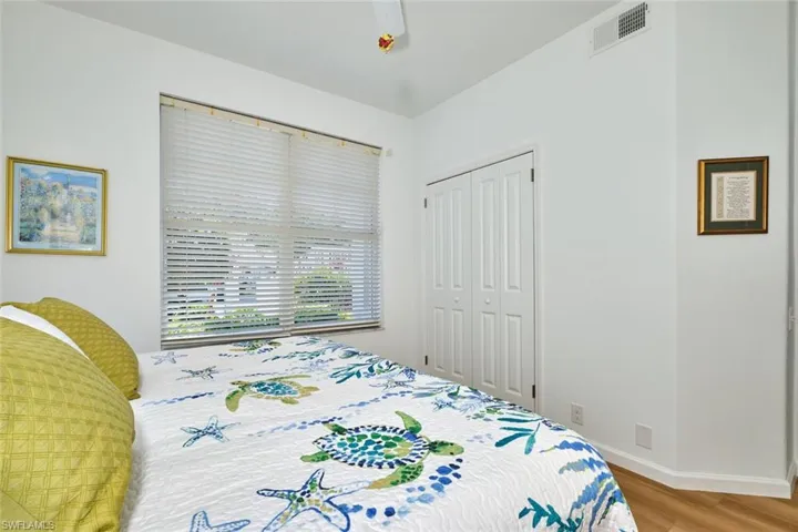 Bedroom with wood finished floors, a closet, baseboards, and a ceiling fan