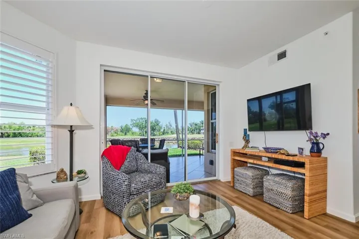 Living room with wood finished floors, a ceiling fan, and baseboards