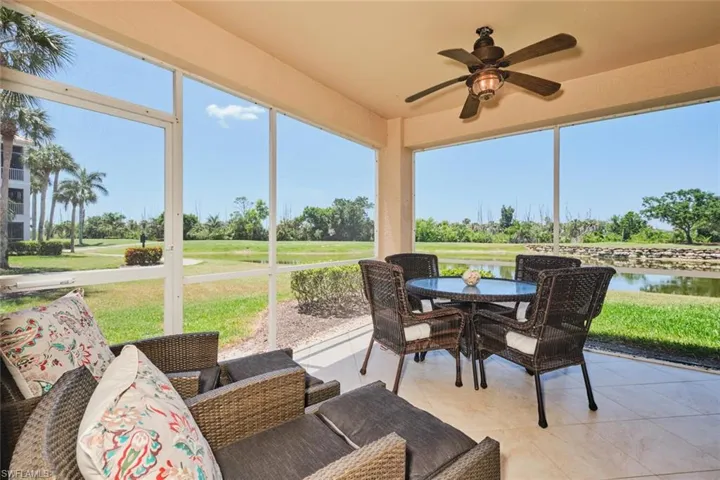 Sunroom / solarium featuring ceiling fan, outdoor dining area, a water view, and view of golf course