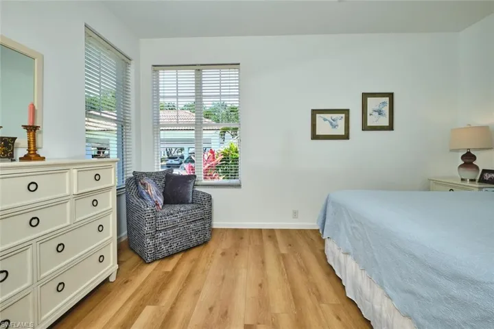 Bedroom with light wood-type flooring, multiple windows, and baseboards