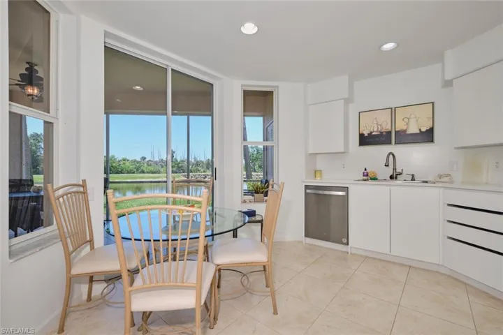 Kitchen with stainless steel dishwasher, a sink, plenty of natural light, white cabinetry, and recessed lighting