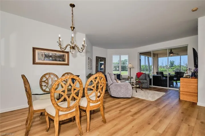 Dining area with a chandelier, light wood finished floors, and baseboards
