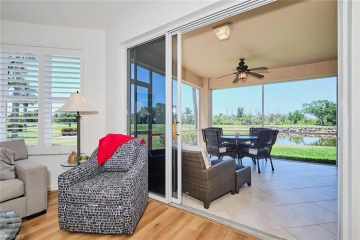 Sunroom / solarium featuring a water view, healthy amount of natural light, and wood finished floors