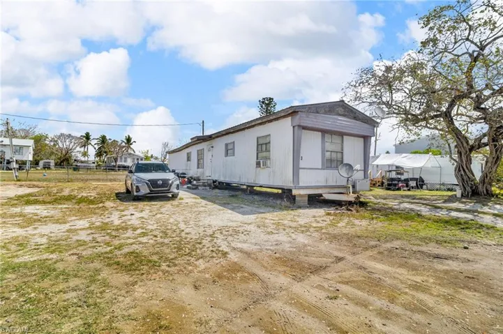 View of property exterior featuring cooling unit and fence