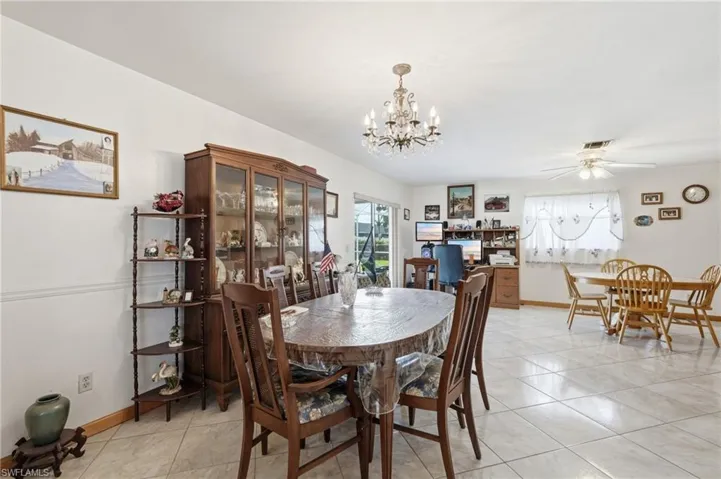 Open-concept living space with tile flooring, a chandelier, and a ceiling fan